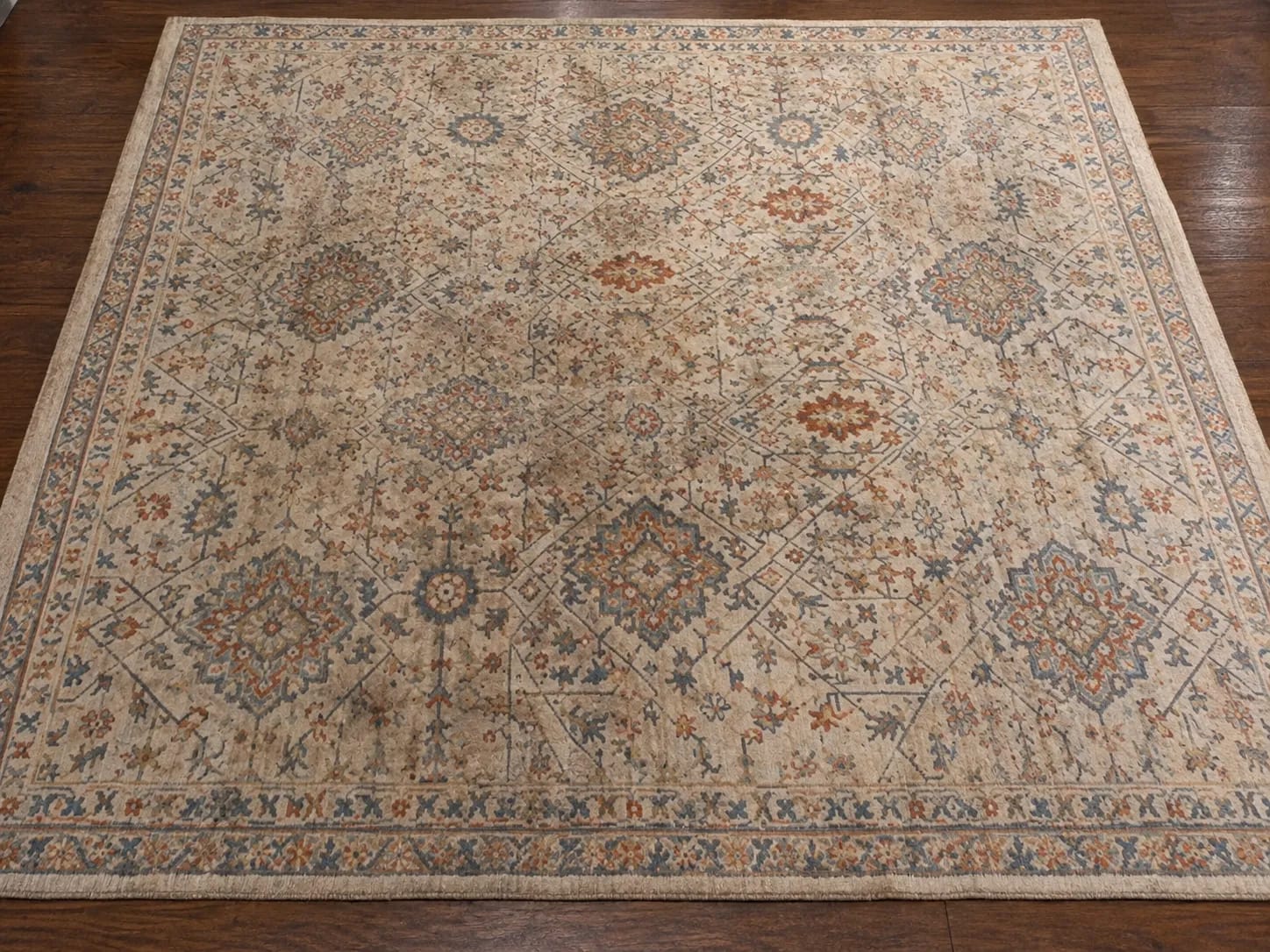Before — patterned area rug with a large brown stain across the center