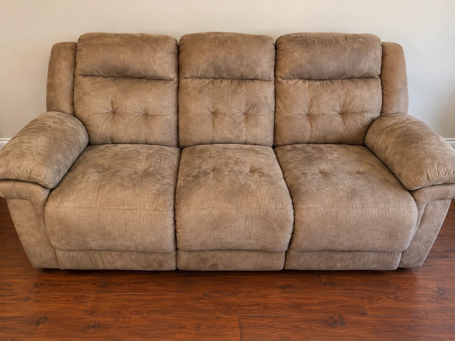Before — tan three-seat reclining sofa with worn, stained cushions